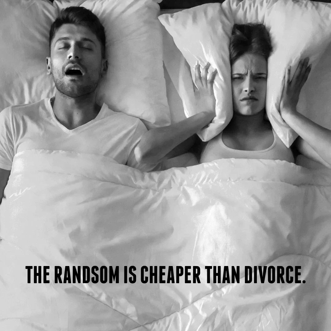 Man snoring with mouth open; woman covers ears with pillow, annoyed