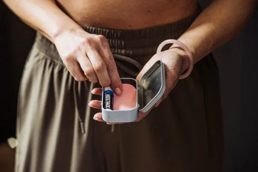 Man taking pink Hostage Tape strip from bedside tin to prevent snoring