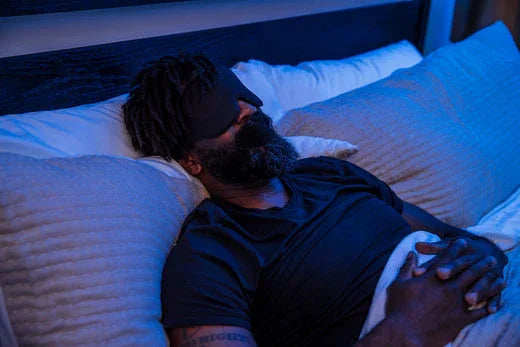 Man sleeping in bed wearing eye mask and mouth tape for deep breathing and better rest