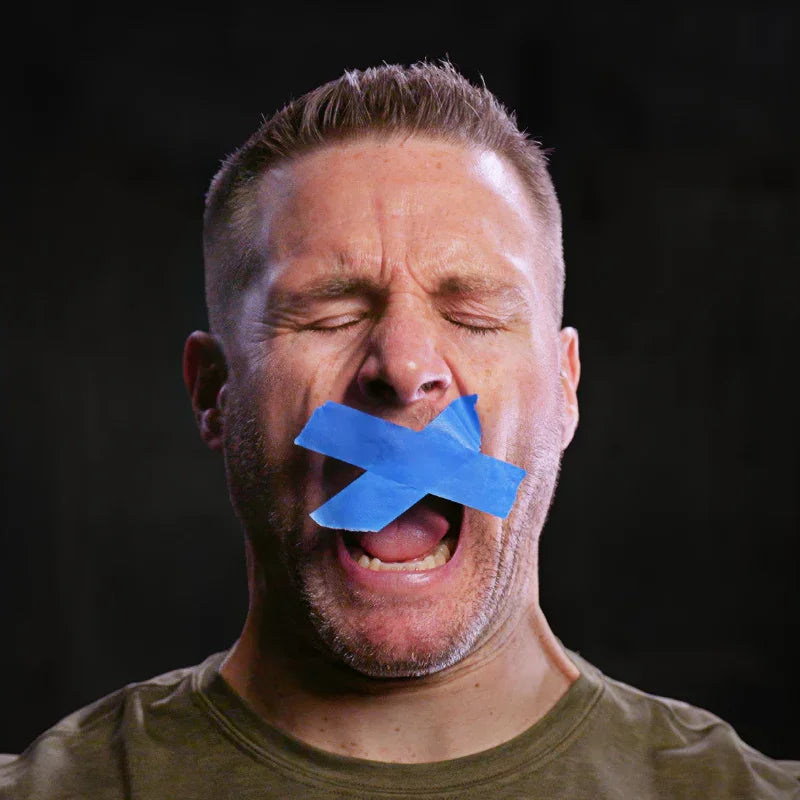 Man with cross-pattern tape over mouth to reduce snoring